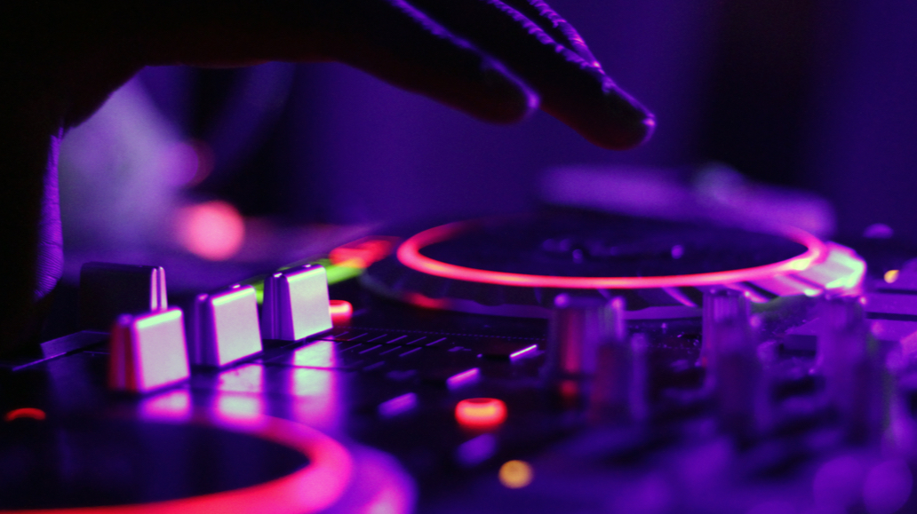 A DJ's hand poised over the turntable during a Bees Knees show.